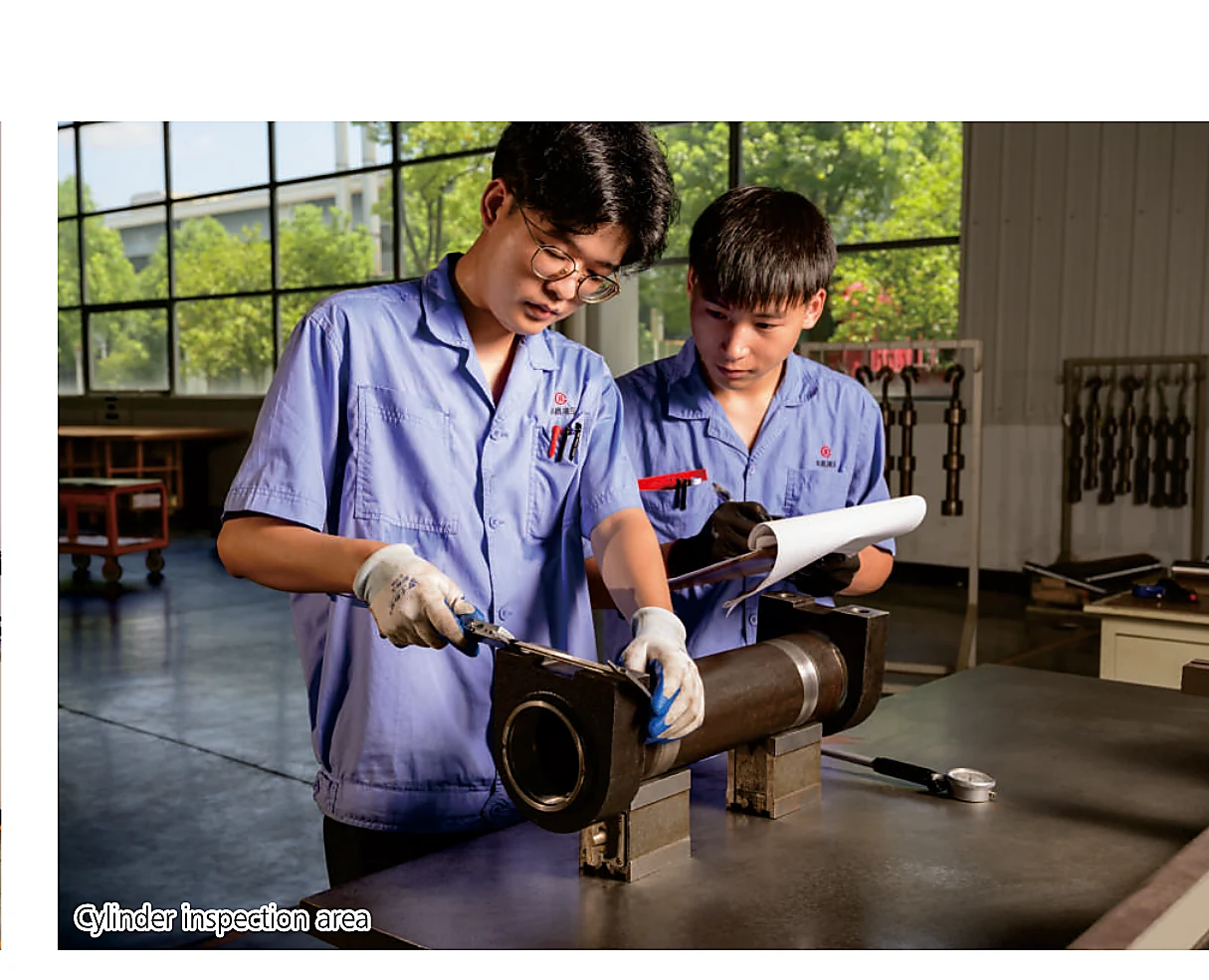 Technicians inspecting a hydraulic cylinder component