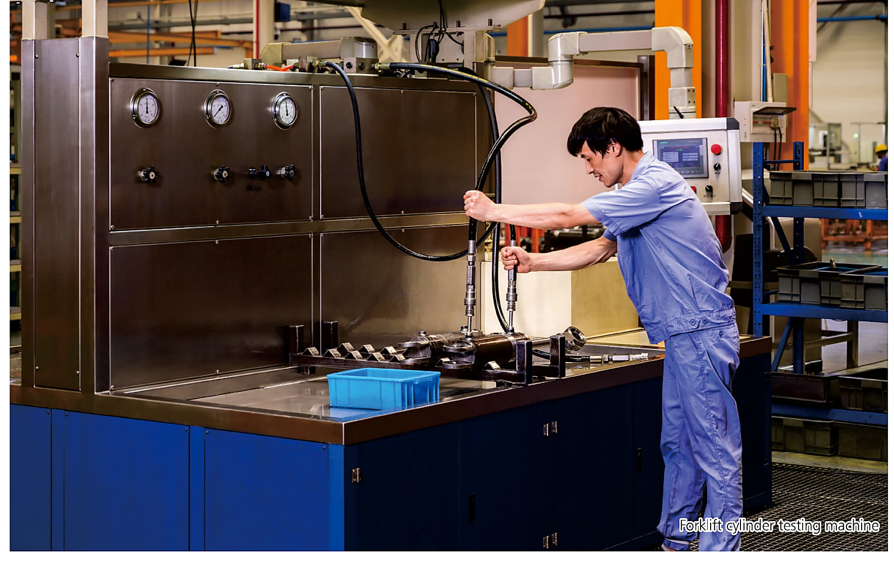 Technician operating hydraulic cylinder pressure testing equipment